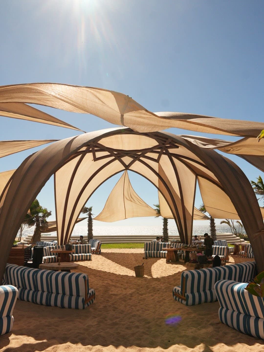 Zona de camastros y palapa lounge junto a la alberca en Mayto